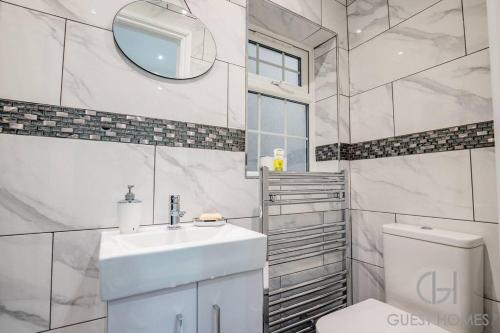 a white bathroom with a sink and a toilet at Guest Homes - Broadland House in Southampton