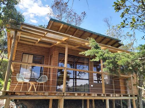 uma casa na árvore construída sobre troncos com um deque em Ecoverso Cabañas del bosque em Medellín