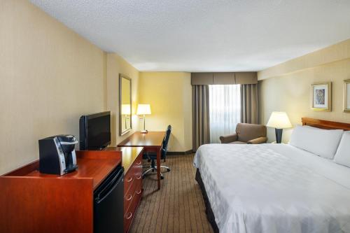 a hotel room with a bed and a desk at Holiday Inn Laval Montreal by IHG in Laval