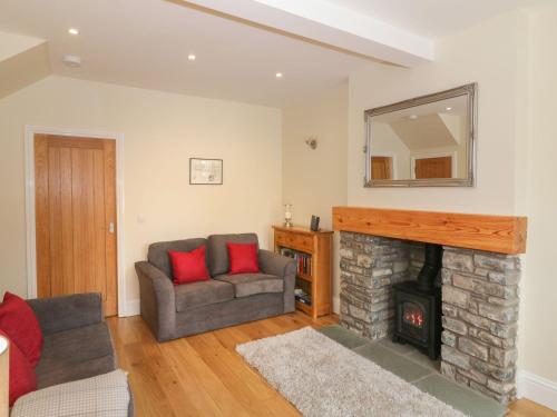 a living room with a couch and a fireplace at Haven Cottage in Kirkcudbright