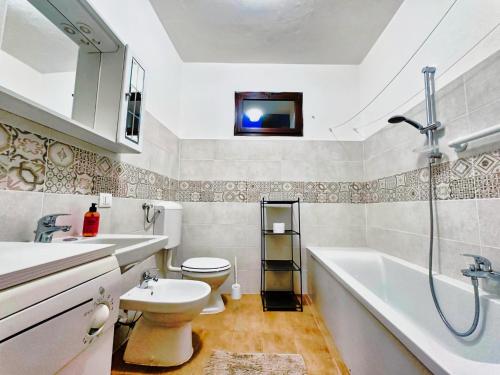 a bathroom with a tub and a toilet and a sink at residenza piccolo diamante a 300m dal centro in Borno