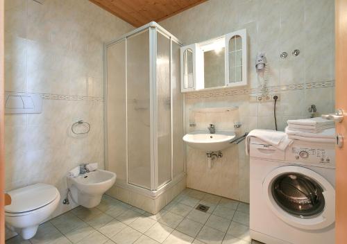 uma casa de banho com um lavatório e um chuveiro. em Appartaments Alpi em Seiser Alm