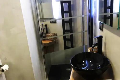 La salle de bains est pourvue d'un lavabo noir et d'une douche. dans l'établissement Joli Appartement Cosy 2 à 4 pers avec terrasse La Fourmi, à Orbey