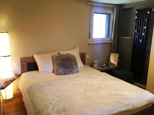 - une chambre avec un lit et un oreiller dans l'établissement Joli Appartement Cosy 2 à 4 pers avec terrasse La Fourmi, à Orbey