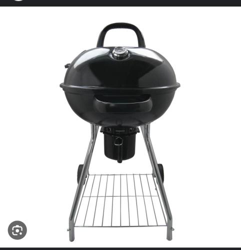 a black grill sitting on a metal stand at Sea La Vie - Holiday Home in Albion