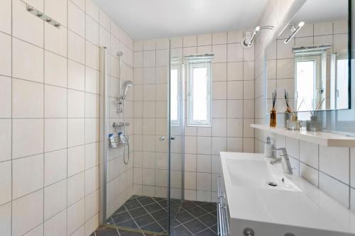 ein Bad mit einer Dusche und einem Waschbecken in der Unterkunft Centrum apartment in Ålesund