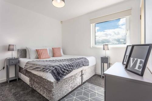 a white bedroom with a bed and a window at Walker Suite No 60 - Donnini Apartments in Kilmarnock
