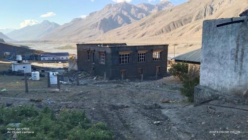 an old building in the middle of a desert with mountains at Sunflower in spiti kee in Kibar