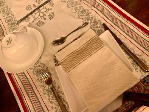 a table with a plate and a fork and spoon at TROIS COURONNES B&B di Charme Appartamenti ad uso turistico VDA La Salle in La Salle