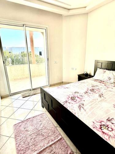 Oasis de Sérénité en Bord de Mer في الدار البيضاء: غرفة نوم بسرير كبير ونافذة كبيرة