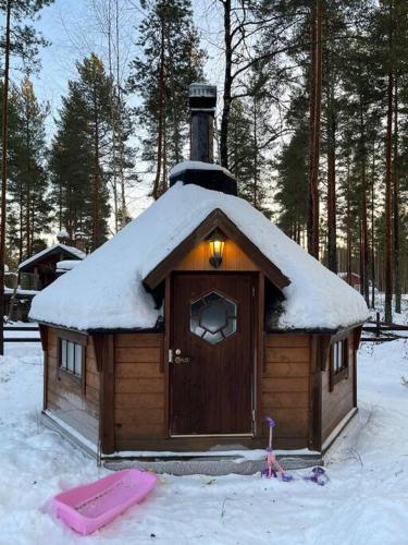 a small house with a snow covered roof in the snow at Villa Kalajärvi in Seinäjoki