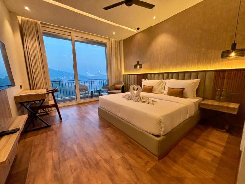 a bedroom with a bed and a large window at ARNISA Kasauli - A Boutique Hotel in Kasauli