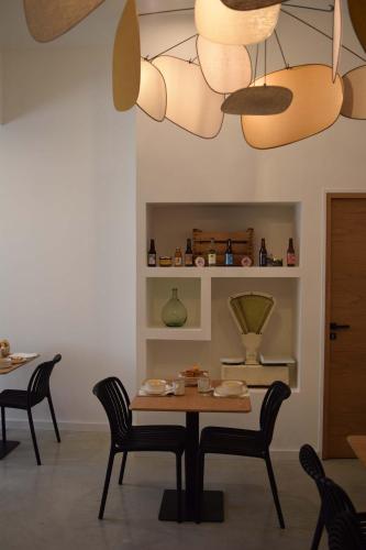 a dining room with a table and chairs and a chandelier at Le Chai in Nissan-lez-Enserune