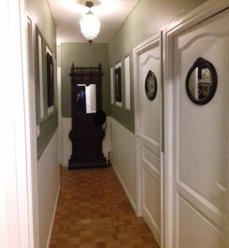 a hallway with a door and a clock on the wall at Au Duc de Sep in Sepmeries