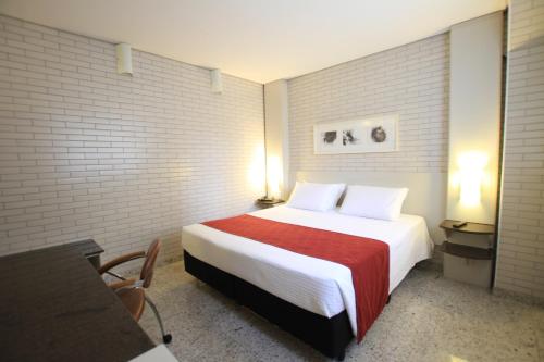 A bed or beds in a room at Hotel Confiance Batel