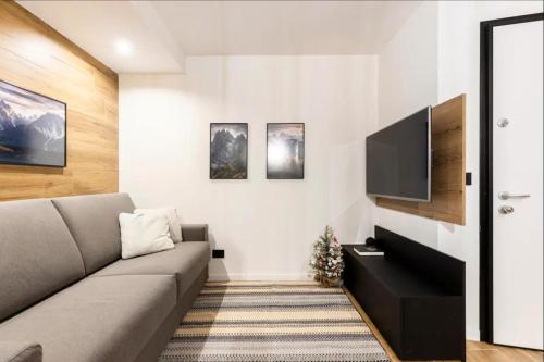 ein Wohnzimmer mit Couch und Flachbildfernseher in der Unterkunft Dolomiti Haus - Immerso nelle Dolomiti in Tesero