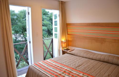 a bedroom with a bed and a large window at Hotel VillaOeste in Mossoró