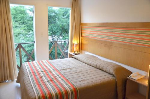 a bedroom with a bed and a large window at Hotel VillaOeste in Mossoró