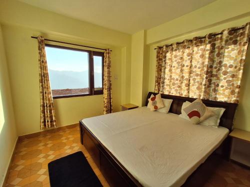 a bedroom with a large bed with a large window at Anand Niketan Homestay Shimla in Shimla