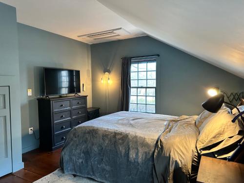 um quarto com uma cama grande e uma televisão em The Saltbox Greenport em Greenport