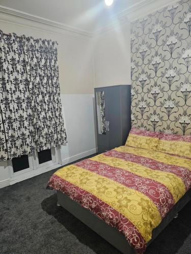 a bedroom with a bed and two windows with curtains at VIkky'S BnB in Birmingham
