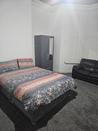 a bedroom with a bed and a couch at VIkky'S BnB in Birmingham