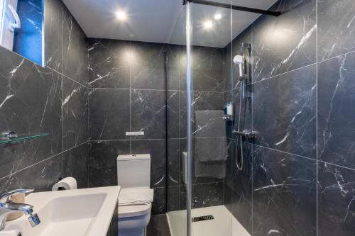 La salle de bains est pourvue d'une douche, de toilettes et d'un lavabo. dans l'établissement Katolondonhaus, à Mitcham
