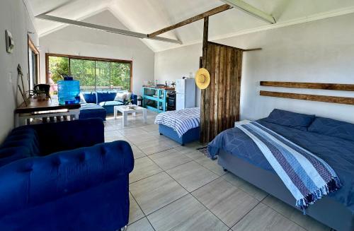 1 dormitorio con 1 cama y sala de estar en Blue Lagoon Cottage en Umngazana