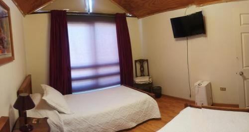 een slaapkamer met een bed en een groot raam bij La Ruta del Jazz in Santa Cruz