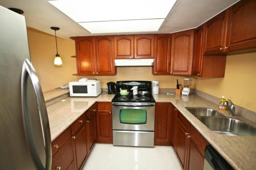 a kitchen with wooden cabinets and a stainless steel stove at Ocean Reef Yacht Club & Resort in Freeport