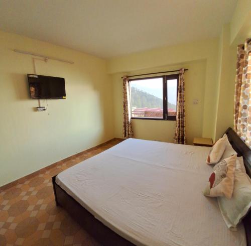 a bedroom with a large bed and a window at Anand Niketan Homestay Shimla in Shimla