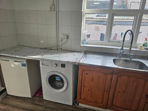 a kitchen with a washing machine and a sink at VIkky'S BnB in Birmingham