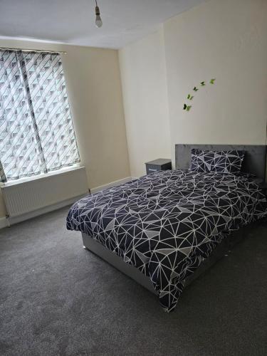 1 dormitorio con 1 cama y 2 ventanas en VIkky'S BnB, en Birmingham