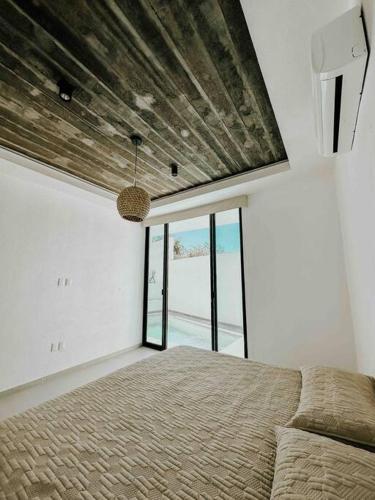 a bedroom with a bed and a large window at Casa Calec 2BR Apartment with Pool & Terrace in Manzanillo