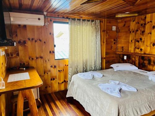 um quarto com uma cama num chalé de madeira em Altos da Serra em São José dos Ausentes