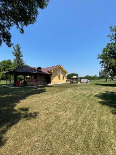 dom z altaną pośrodku pola w obiekcie Vila Meadow 