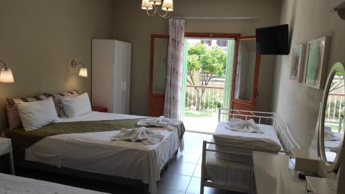 a bedroom with two beds and a sliding glass door at Kallisti Seaside Studios Skopelos in Agnontas