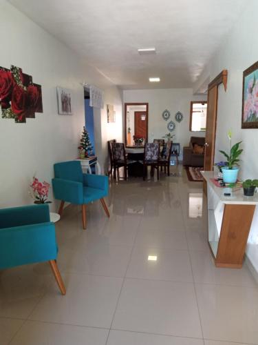 a living room with blue chairs and a table at Casa com piscina no imbé in Imbé