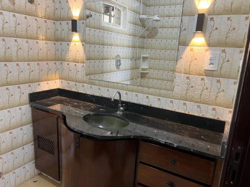 a bathroom with a sink and a mirror at Suíte Príncipe Charles Ceres0021 in Cuiabá