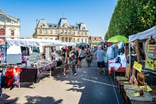 a group of people walking through an outdoor market at Chalet Au bois du Haut Folin in Saint-Prix