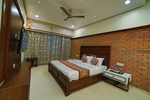 阿布山的住宿－Hotel Mid Town Inn Nakki Lake 500 Metter，一间卧室设有一张床和砖墙