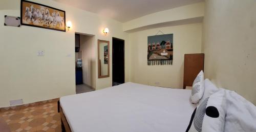a bedroom with a white bed in a room at Anand Niketan Homestay Shimla in Shimla