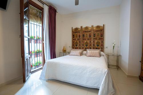 ein Schlafzimmer mit einem Bett und einem großen Fenster in der Unterkunft Casa la Mezquita con parking gratis in Córdoba
