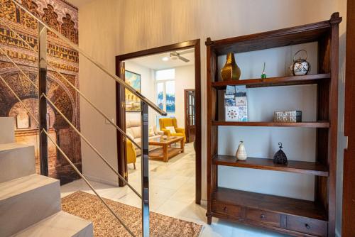 a living room with a stairwell with shelves and a mirror at Casa la Mezquita con parking gratis in Córdoba