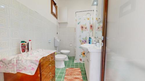 La salle de bains est pourvue d'un lavabo, de toilettes et d'une douche. dans l'établissement Aura Salenta - A 400m dal mare, à San Pietro in Bevagna