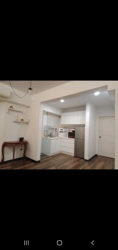 a large kitchen with white cabinets and a table at MAIN PLACE USJ21 SUBANG JAYA in Subang Jaya