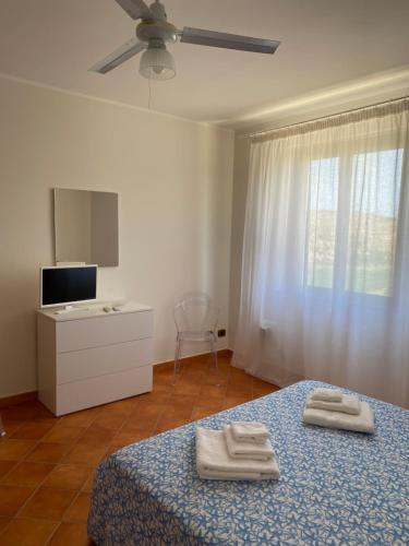 1 dormitorio con 1 cama con 2 toallas en Baglio Quadrone bovo Marina, en Montallegro