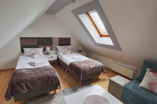 a attic room with two beds and a couch at Apartament Esja in Szczecin