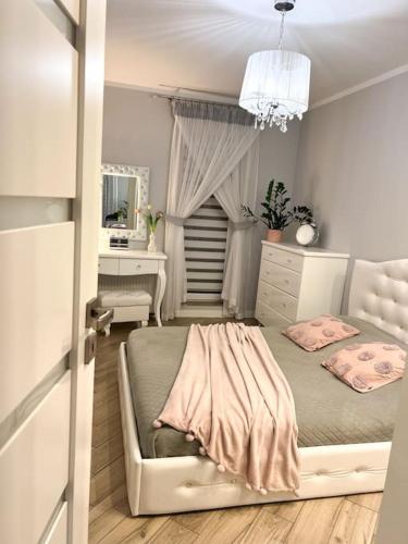 a bedroom with a bed and a desk and a mirror at Apartament Zamojski Młyńska in Zamość