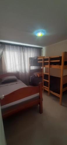 1 dormitorio con 2 literas y una luz en el techo en Linda y acogedora casa en Coquimbo en Coquimbo